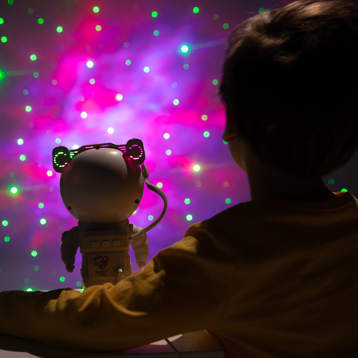Young boy watches stars with astronaut toy